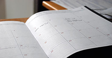A close-up image of a white calendar day planner.