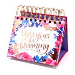 A Bloom brand, spiral ring, undated desktop calendar. Cover includes floral designs and This Year Is For Blooming text in gold cursive font.