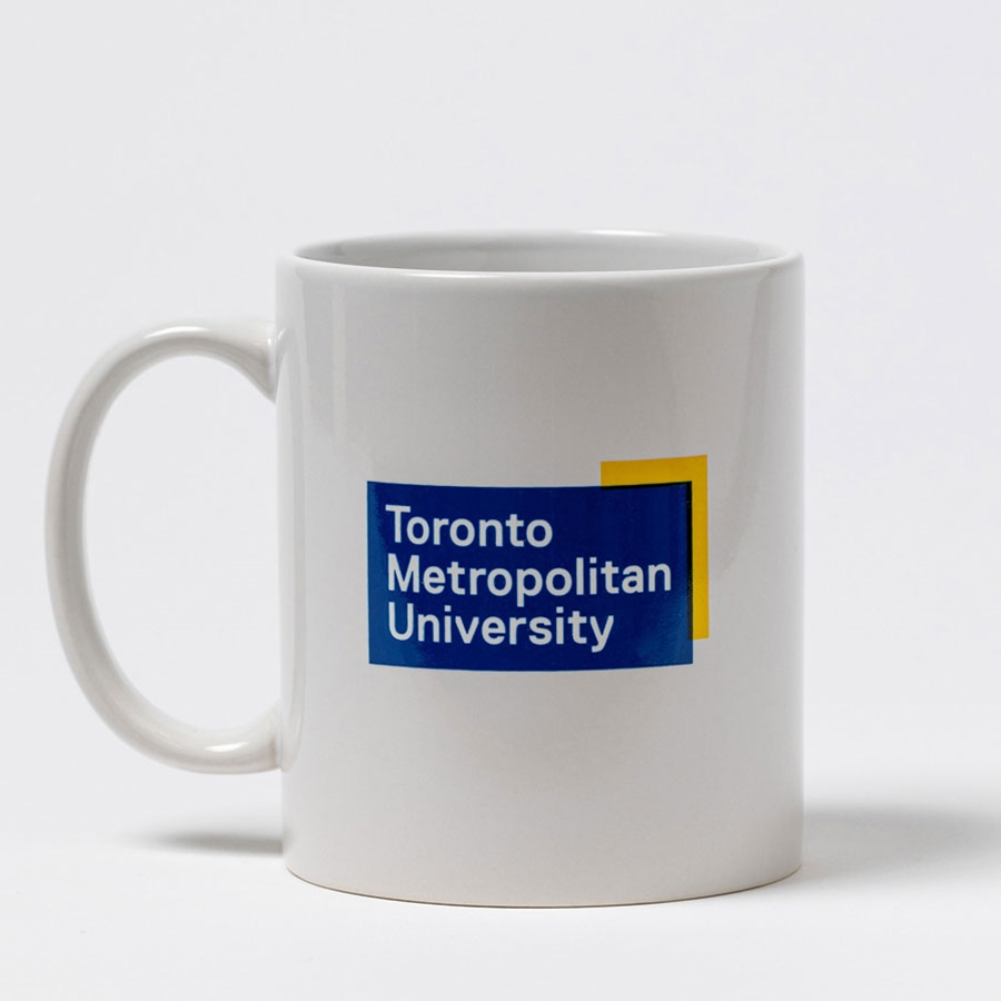 A 11oz white ceramic mug features the full colour "Toronto Metropolitan University" university logo.