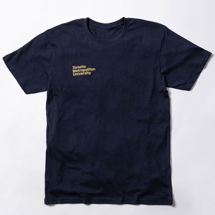A  short-sleeved navy t-shirt features a printed "Toronto Metropolitan University" small stacked wordmark logo on the front right chest in embroidered metallic gold.